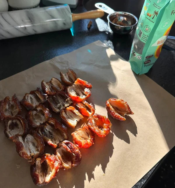 Sunlit kitchen counter background with halved dates prepared for a Just Date recipe.